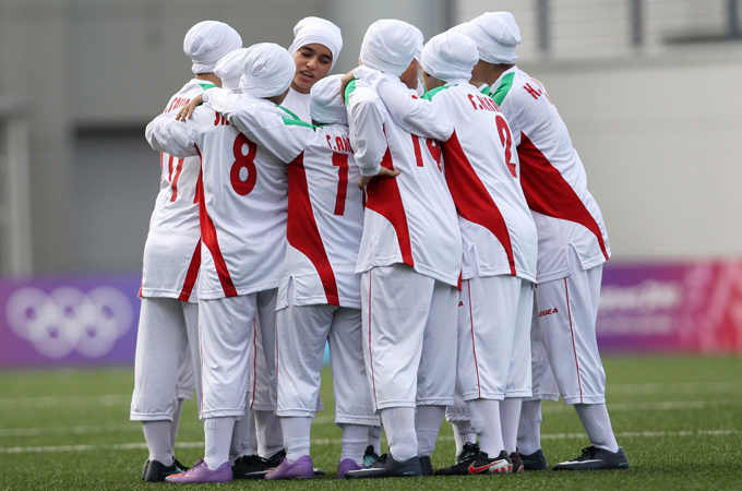 epa02283942 Iranian girls team members hug before their Girls Group A match against Turkey during the Youth Olympic Games (YOG) in Singapore, on 12 August 2010. The first match of the inaugural Youth Olympic Games started even ahead of the official opening ceremony which is to be held on 14 August 2010. Turkey won the match against Iran, who made a surprise entry into the YOG and after they were originally barred from the competition by both the International Olympic Committee and FIFA for the traditional Islamic head dress worn by the girls. The team was reinstated to the tournament after Iran reached a compromise with FIFA to allow the team's members to wear modified hats instead of head scarves.  EPA/STEPHEN MORRISON